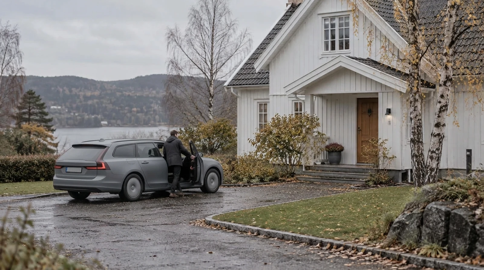 Person som kliver in i en mörk kombi på uppfarten framför en vit trävilla.