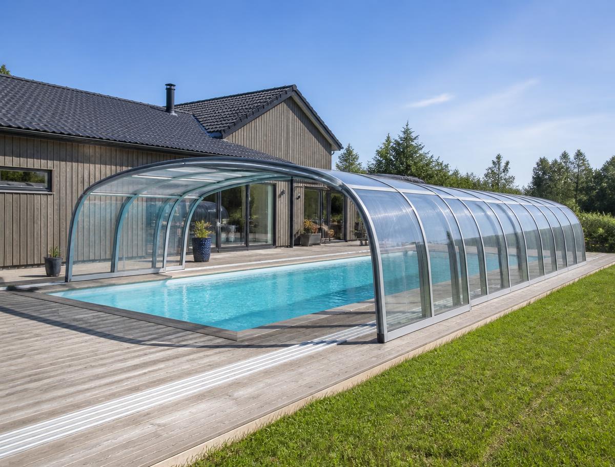Skjutbart pooltak i glas över en pool i en skandinavisk trädgård